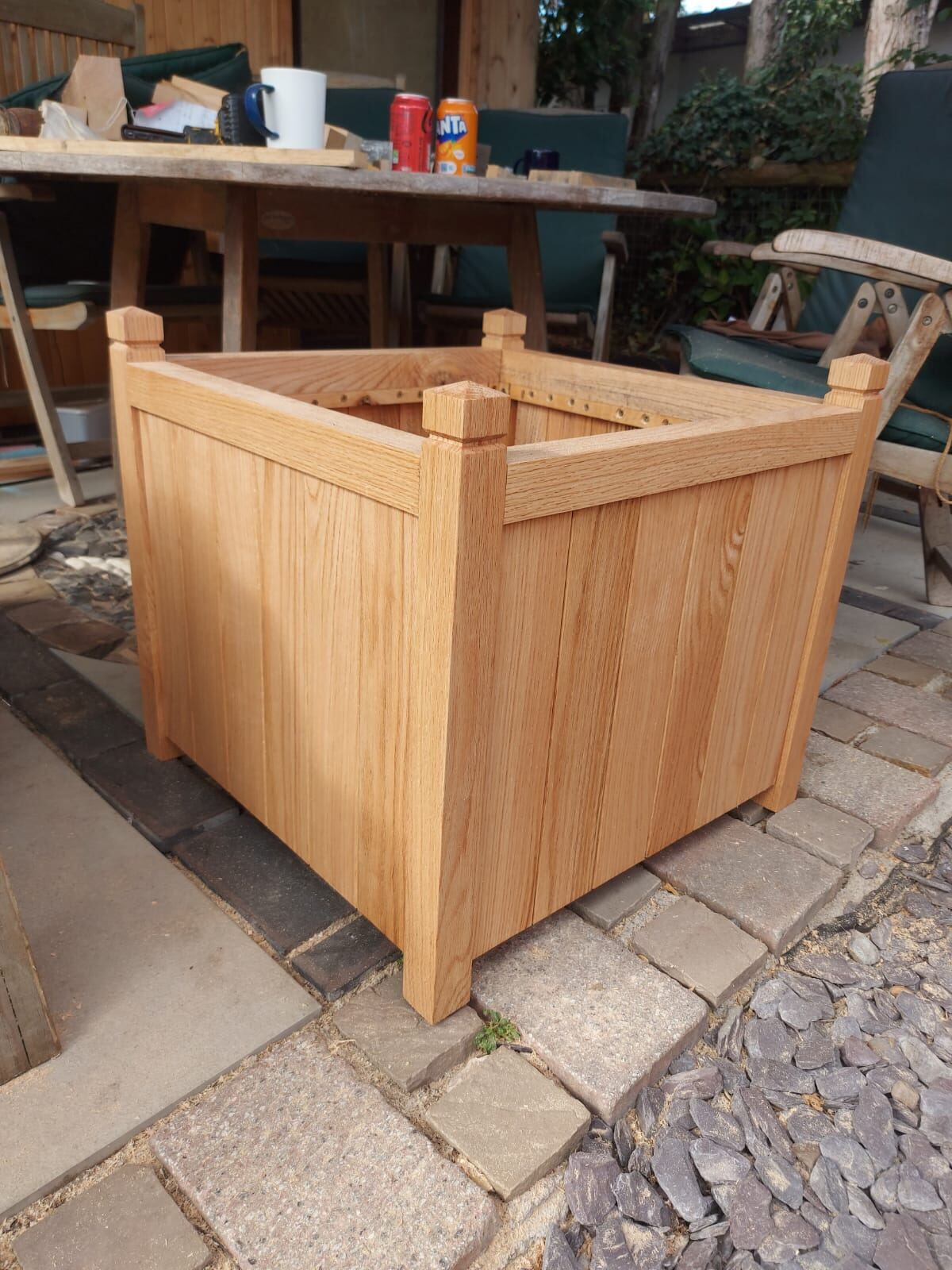 Square solid oak garden planter on a slate patio