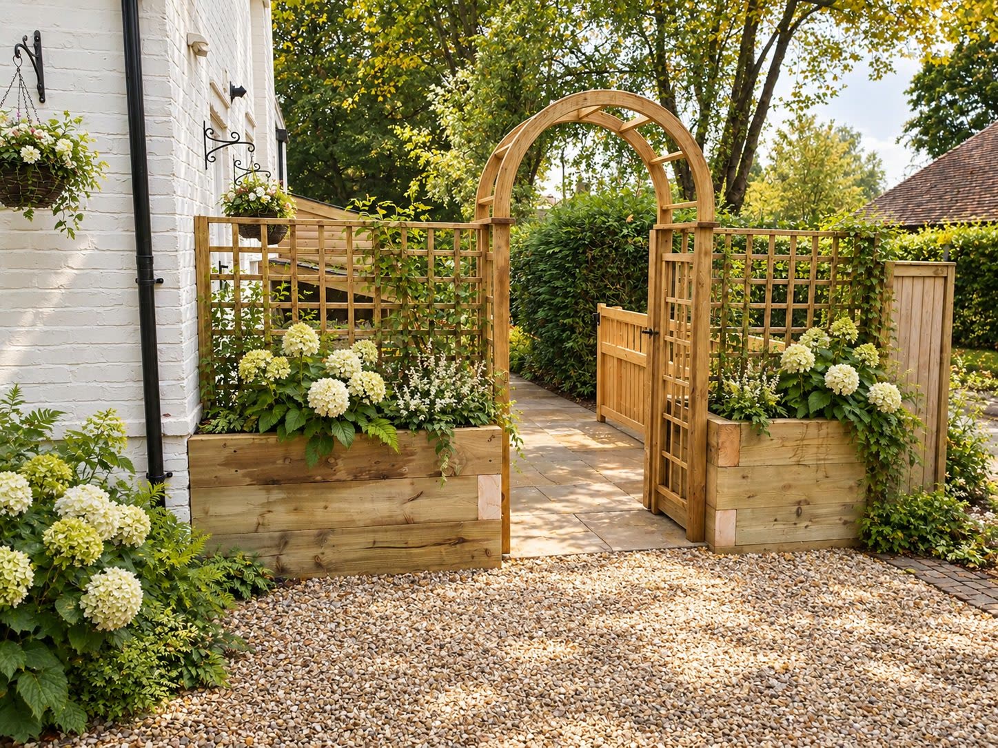 Solid oak garden arch with a gate between sleeper planters at a garden entrance